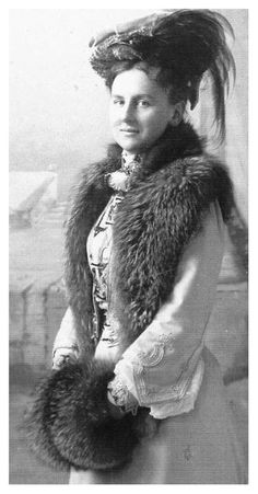 an old black and white photo of a woman wearing a fur stole