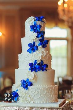 a white and blue wedding cake with flowers on the top is featured in an instagram