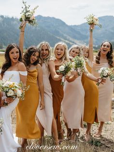 a group of women standing next to each other holding bouquets in their hands and smiling