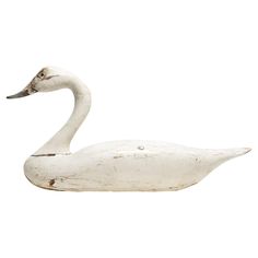 a white swan statue sitting on top of a white surface