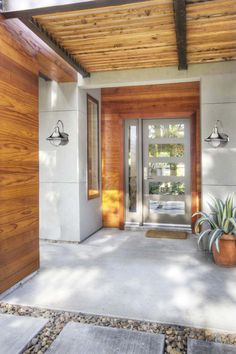 the entrance to a modern home with wooden doors