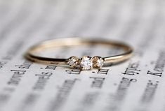 three stone ring sitting on top of an open book