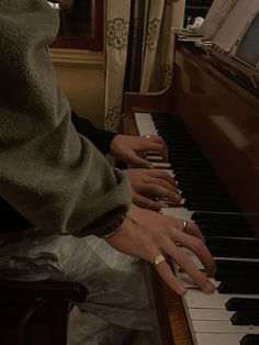 a person sitting at a piano with their hands on the keys