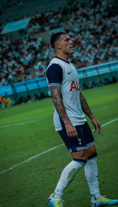 a soccer player is standing on the field in front of an empty stadium full of people