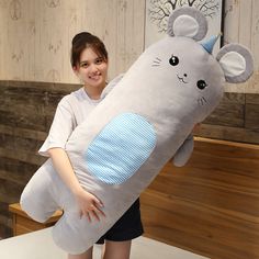 a woman is holding a large stuffed animal