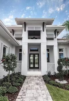 a white house with black shutters and palm trees