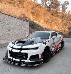 a white and black car parked in front of a building on the side of a road