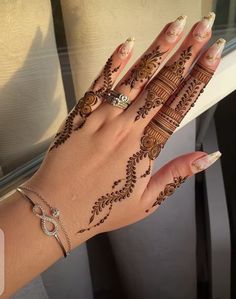 a woman's hand with henna tattoos on it