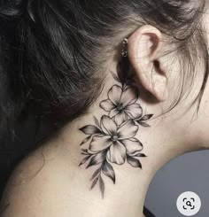 a woman's neck with a flower tattoo on her left side ribcage