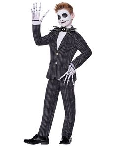 a man in a suit and tie with his hand up to the side, wearing skeleton makeup