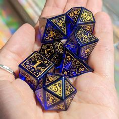 a hand holding a set of blue and gold dice