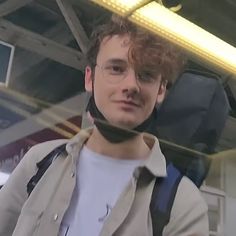 a young man with glasses and a scarf around his neck