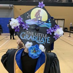 a graduate's cap decorated with flowers and the words, the little graduate