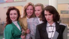 four women standing together in front of a chalkboard