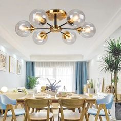 a dining room table with blue chairs and a chandelier hanging from the ceiling