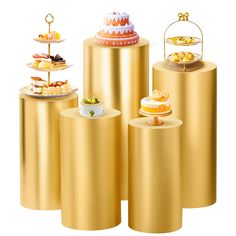 there are many different cakes on top of gold pedestals with plates and trays