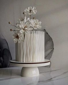 a cake with white icing and flowers sitting on top of a marble countertop