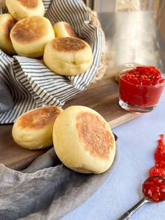 some buns are sitting on a cutting board with ketchup