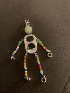 a keychain with beads and charms attached to it's side on a black surface