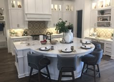 a large kitchen with white cabinets and an island