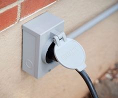 an electrical outlet attached to a brick wall