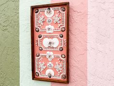 a pink and green wall with a decorative piece on it