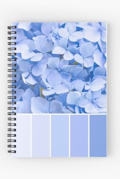 a spiral notebook with blue flowers in the middle and color swatches on each side