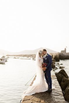 a bride and groom kissing on the dock