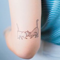 a woman with a cat and dog tattoo on her arm