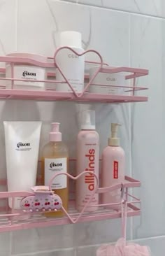 a pink shelf filled with different types of personal care products on top of a white tiled wall