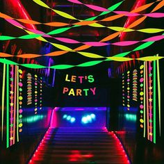 neon lights and streamers decorate the ceiling in this party themed dance floor area for a children's birthday celebration