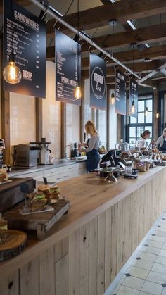 people are sitting at the counter in a restaurant with many menus hanging from the ceiling