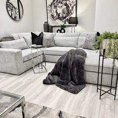 a living room filled with lots of furniture next to a wall mounted painting on the wall