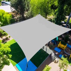 an overhead view of a play area with trees and playground equipment in the background, from above