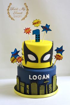 a birthday cake with the name logan on it, decorated like a superhero mask