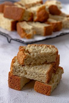 several pieces of bread stacked on top of each other in front of a plate full of them