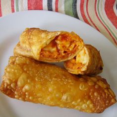 two pastries sitting on top of a white plate next to a striped table cloth