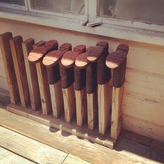 some wood logs are lined up on the side of a wooden building near a window