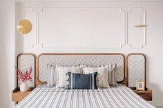 a bed with blue and white striped bedspread next to a wooden headboard