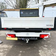 the back end of a white truck parked in a parking lot