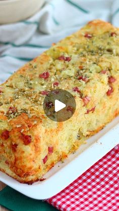 a loaf of bread on a plate with a red and white checkered table cloth