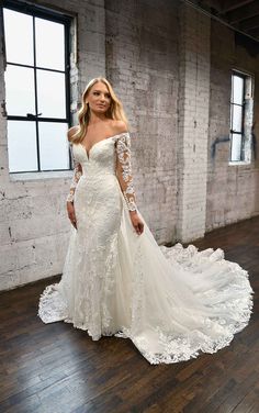 a woman in a wedding dress standing on a wooden floor