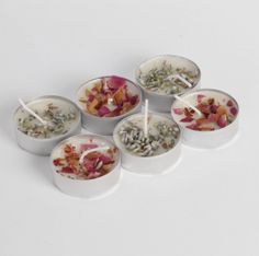 six bowls with different types of food in them on a white surface, each containing spoons