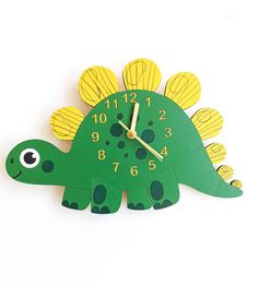 a green dinosaur clock with yellow numbers on it