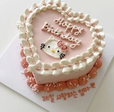 a heart shaped cake with hello kitty frosting on it's top and happy birthday written in the middle