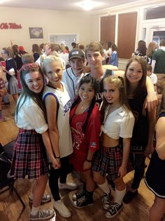 a group of young people standing next to each other on a hard wood floored room floor