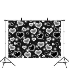 a black and white photo with hearts on the wall in front of an empty backdrop