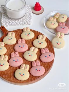 some bunny cookies are on a plate next to cups