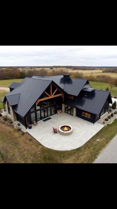 an aerial view of a large house with a fire pit in the middle of it