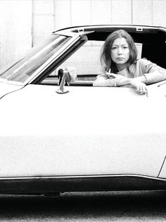 a woman sitting in the back of a white car